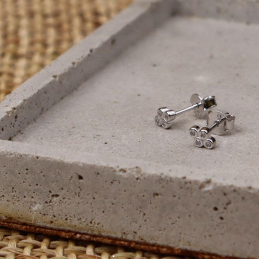 goldsilver stud earrings displayed on a jewellery tray
