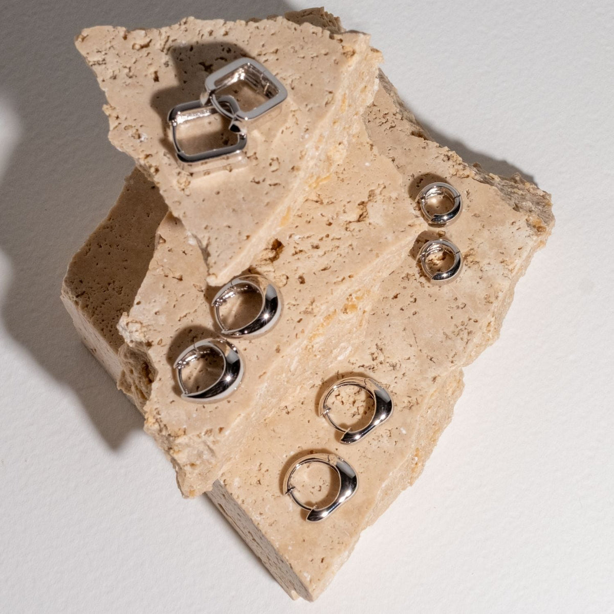 modern silver earrings on terrazzo stone