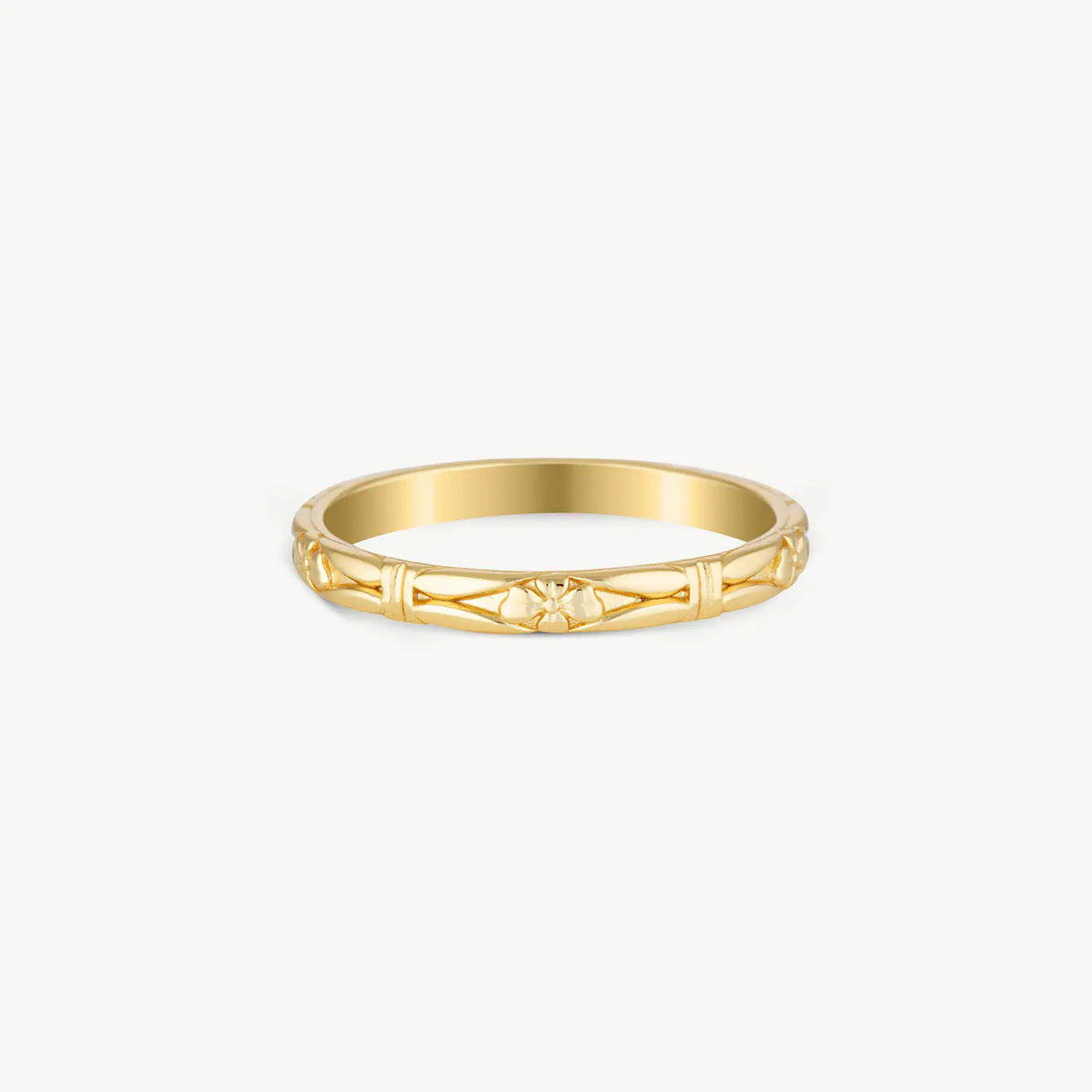 A delicate yellow gold band ring with a geometric openwork pattern, photographed on a clean, light off-white background.