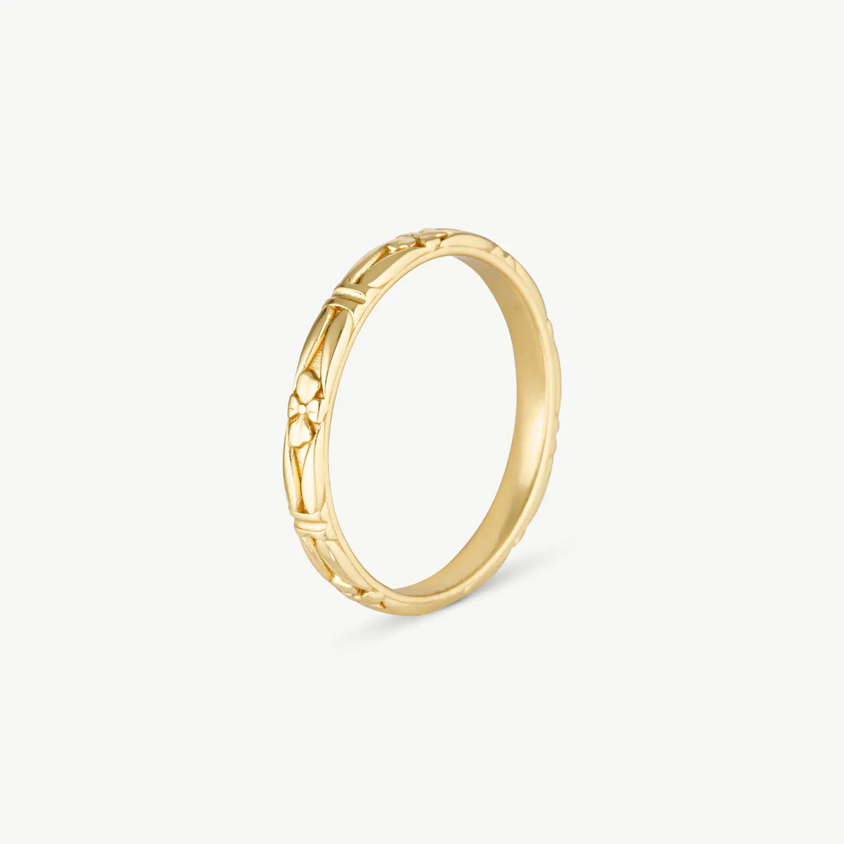 A gold band ring with a textured, openwork geometric pattern on the outer surface, shown on a light gray background.