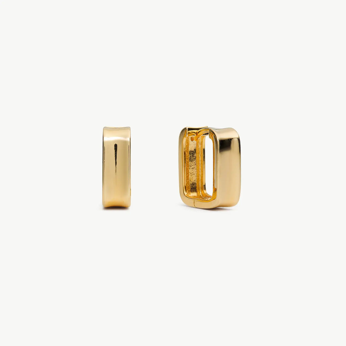 Rectangular gold earrings on cream background