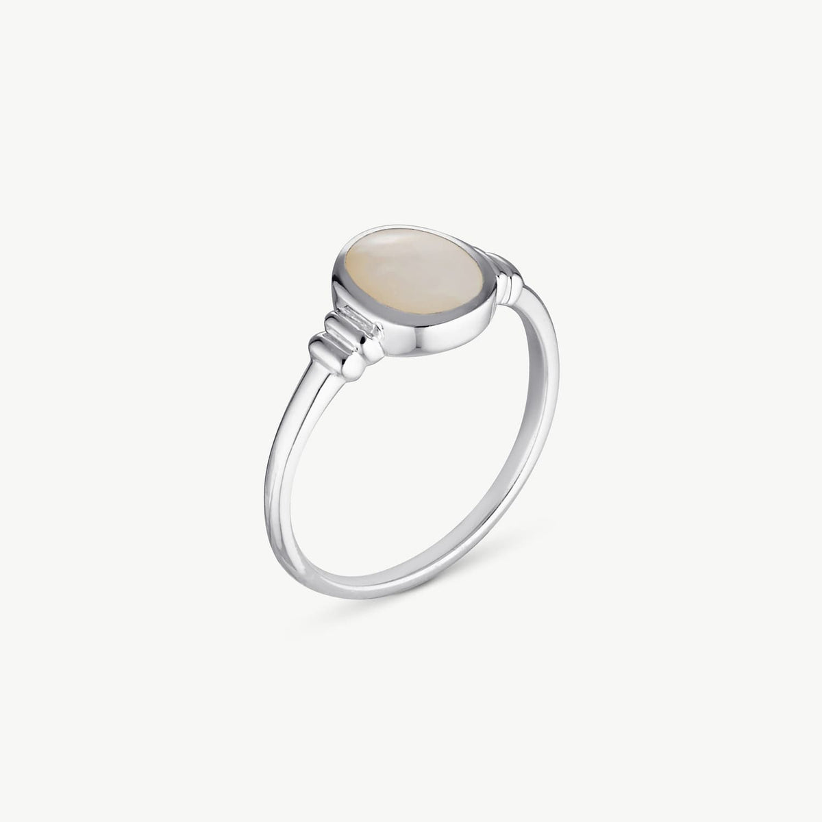 A silver ring featuring a smooth, oval-shaped cream-colored stone in a bezel setting, shown on a clean off-white background.