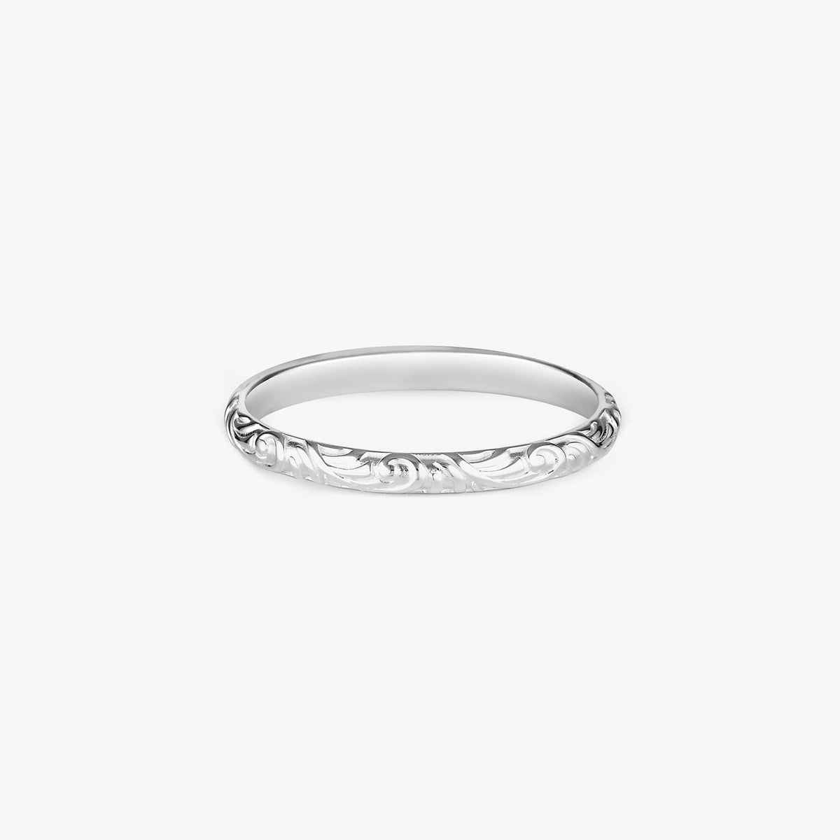 A thin silver band ring with an engraved floral scroll pattern, shown against a plain light gray background.