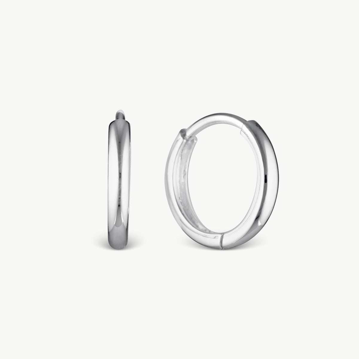 A pair of polished silver hoop earrings shown on a clean, light off-white background, with one earring standing vertically to show its profile and the other lying horizontally to show its front view.