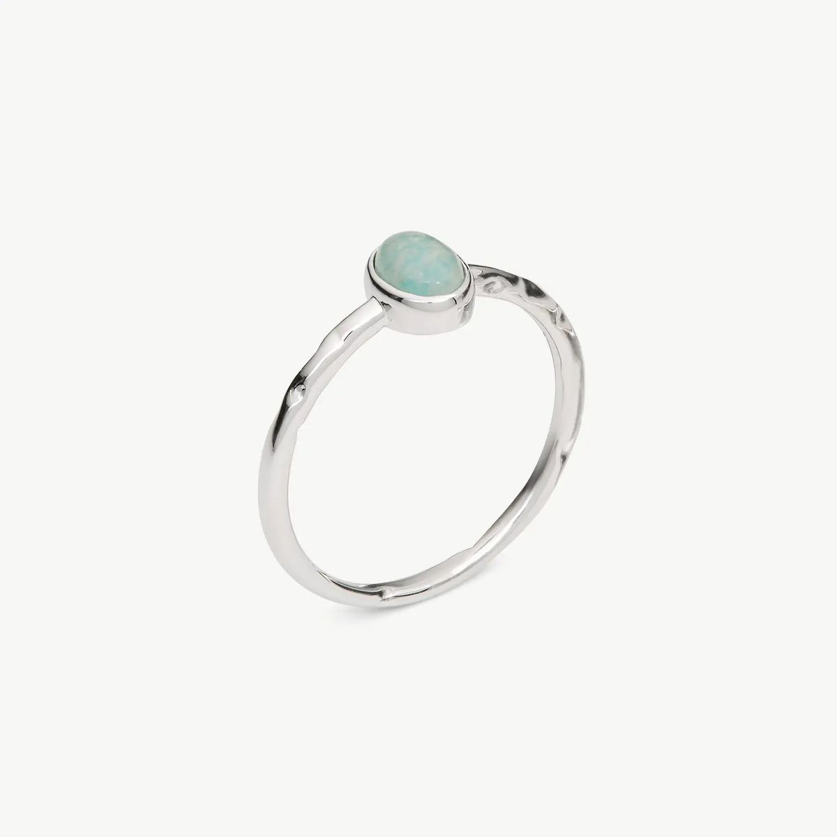 A silver ring featuring a small, oval-shaped light blue gemstone in a bezel setting, shown on a plain light gray background.