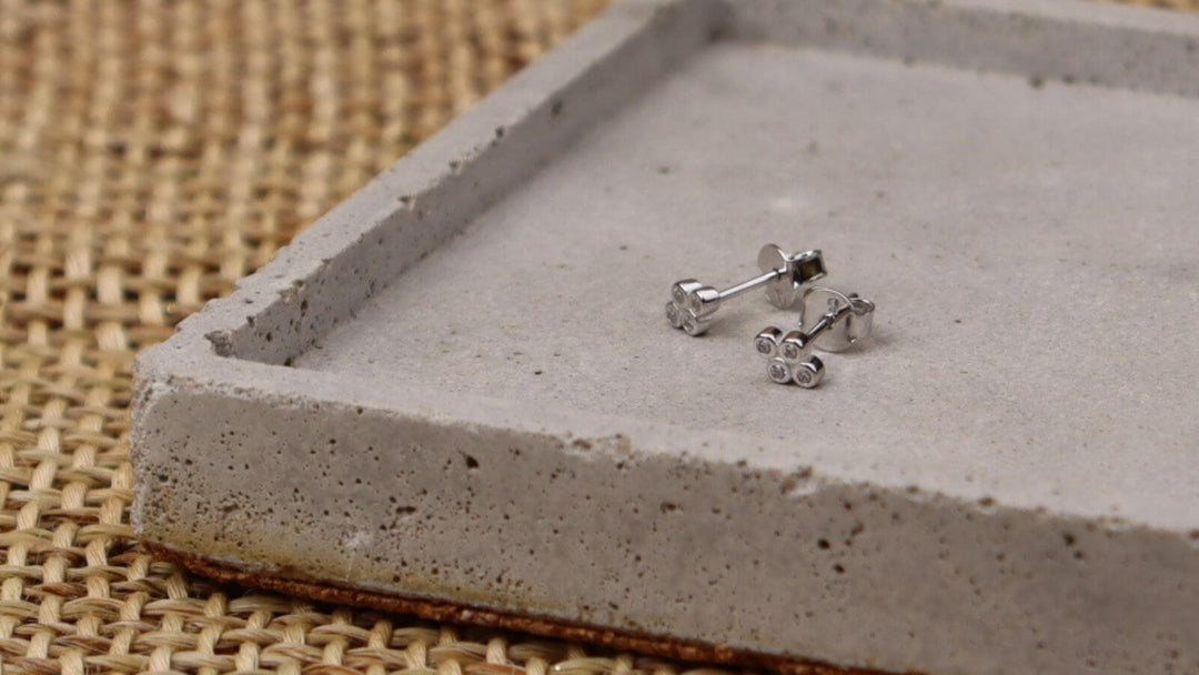 goldsilver stud earrings displayed on a jewellery tray