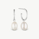 A pair of silver hoop earrings with dangling baroque pearl drops, shown against a clean off-white background.