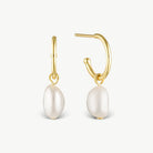 A pair of gold hoop earrings with dangling baroque pearl drops, shown on a clean off-white background.