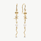 A pair of gold dangle earrings featuring starfish, seashell, pearl, and wavy chain details, shown against a plain off-white background.