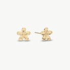 A pair of gold flower stud earrings with a textured, hammered finish, displayed on a clean off-white background.