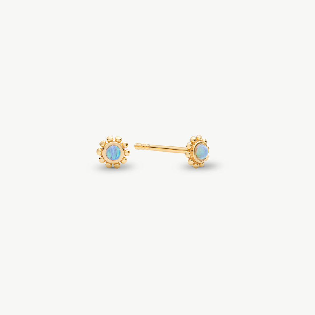 A pair of gold stud earrings with round iridescent opal-like centers, shown on a clean off-white background.