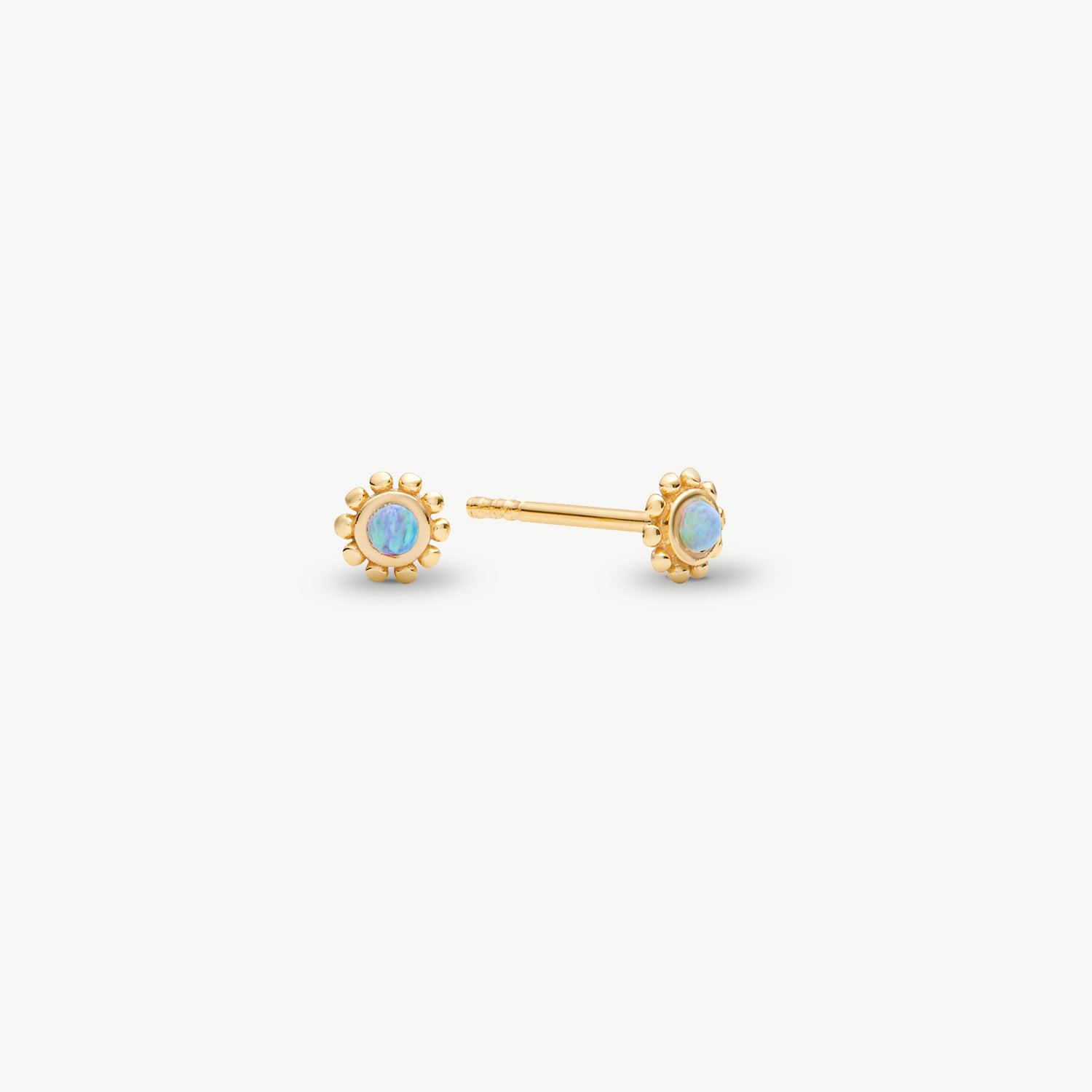 A pair of gold stud earrings with round iridescent opal-like centers, shown on a clean off-white background.