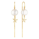 Pearl and starfish earrings with gold chains on a white background