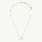 A delicate gold chain necklace featuring two interlocking open circular pendants, displayed on a clean, light off-white background.