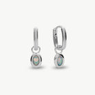 A pair of silver huggie hoop earrings with oval opal inlays, shown on a clean off-white background.