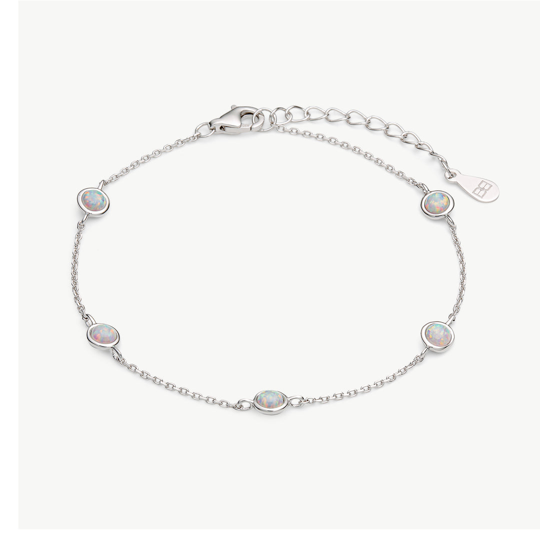 A delicate silver chain bracelet featuring five oval-cut iridescent opal stones, displayed on a clean off-white background.