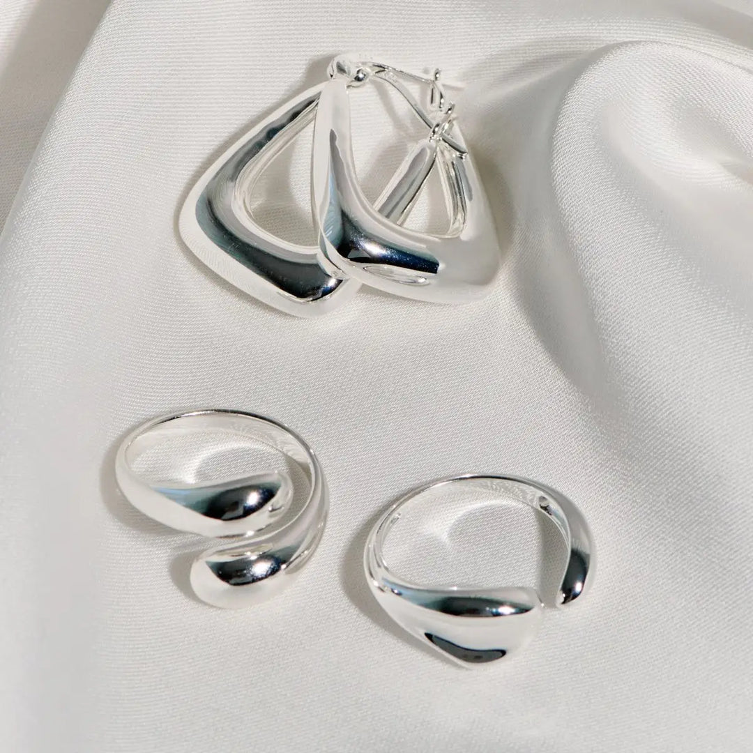 Set of silver earrings on a white fabric background
