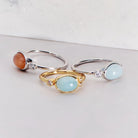 Three rings with gemstones on a light gray background