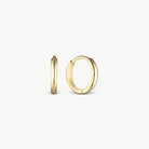 Gold thin huggie earrings on creabackground
