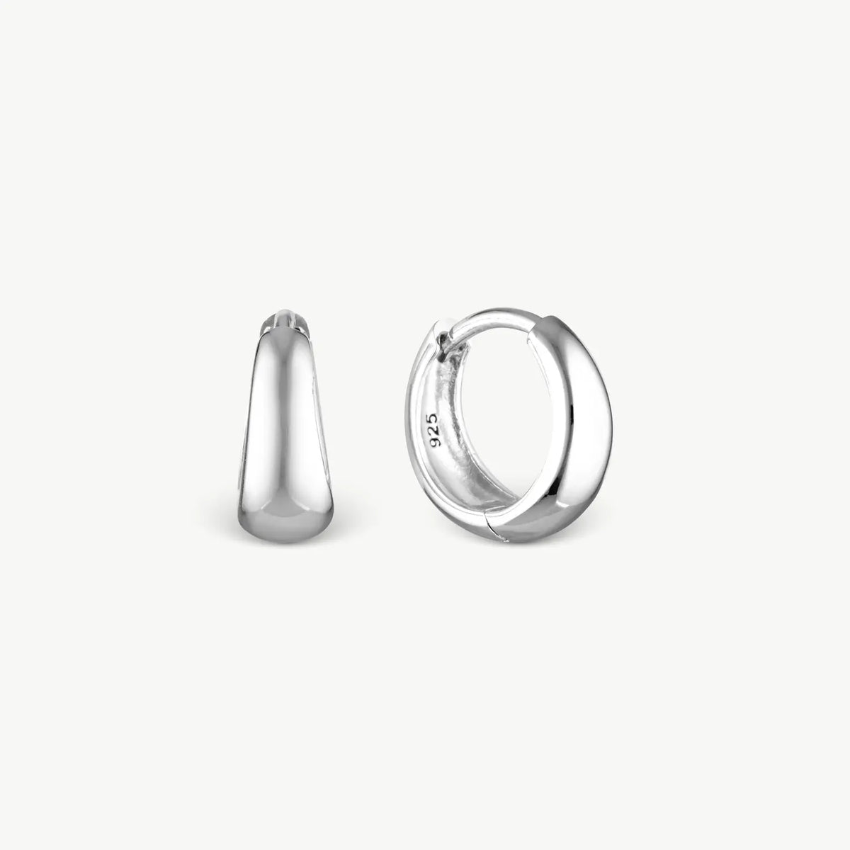 A pair of polished sterling silver huggie hoop earrings shown from two angles, one side profile and one front-three-quarter view, on a clean off-white background.