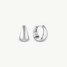Wide silver tapering earrings on a cream background