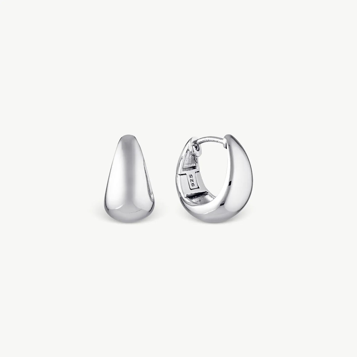 Wide silver tapering earrings on a cream background
