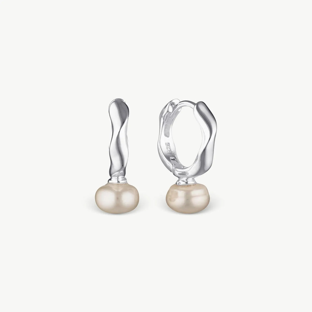 A pair of silver huggie hoop earrings with a twisted vertical bar and a round freshwater pearl drop, shown on a light off-white background.