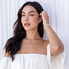 Woman wearing a white off-shoulder top against a white background